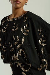 Black maxi dress with gold sequin floral embellishment, flowing sheer sleeves and full-length silhouette, Ambretta by Frock and Frill.