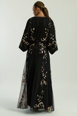 Black maxi dress with gold sequin floral embellishment, flowing sheer sleeves and full-length silhouette, Ambretta by Frock and Frill.
