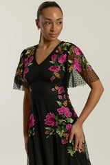 Frock and Frill Elena black midi dress with colourful floral embroidery, sheer polka dot mesh overlay, V neckline and flared sleeves.