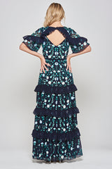 Jasmine navy maxi dress by Frock and Frill with floral embroidery, ruffled tiered skirt, and sheer flutter sleeves, styled for weddings and garden parties.