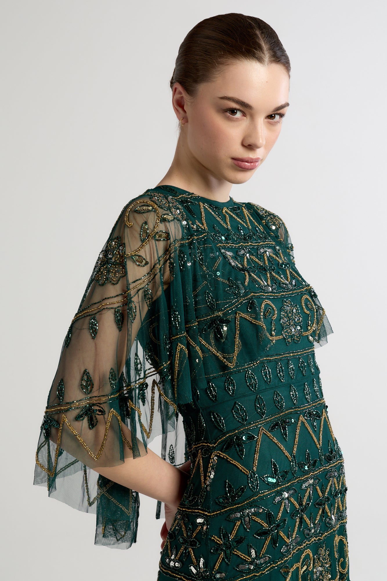 Mahonia by Frock and Frill green embellished midaxi dress with cape sleeves. 