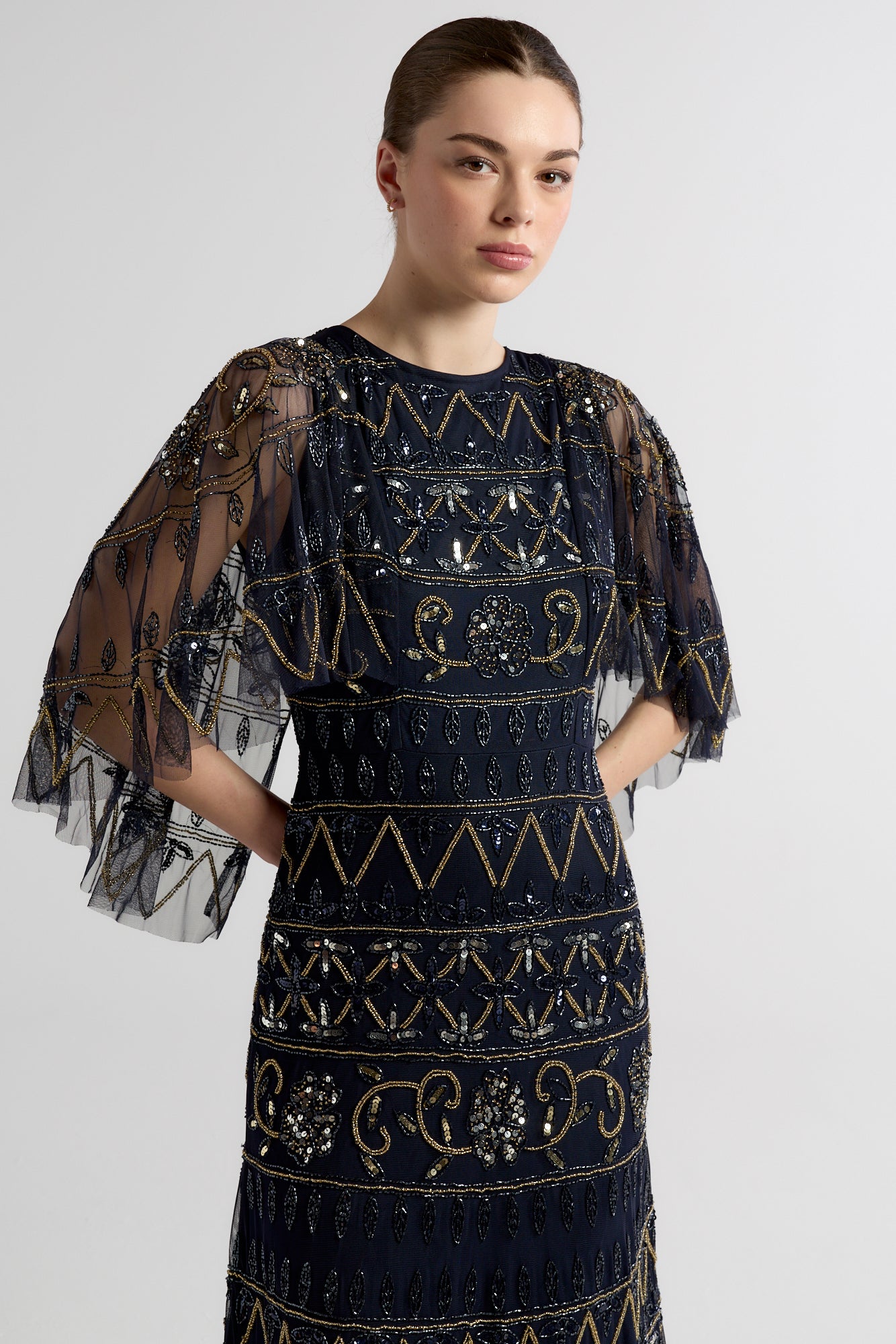 Navy Mahonia cape sleeve midaxi dress from Frock and Frill, fully embellished with sparkling beads, featuring a flowing skirt, perfect for weddings, parties, and modest evening occasions