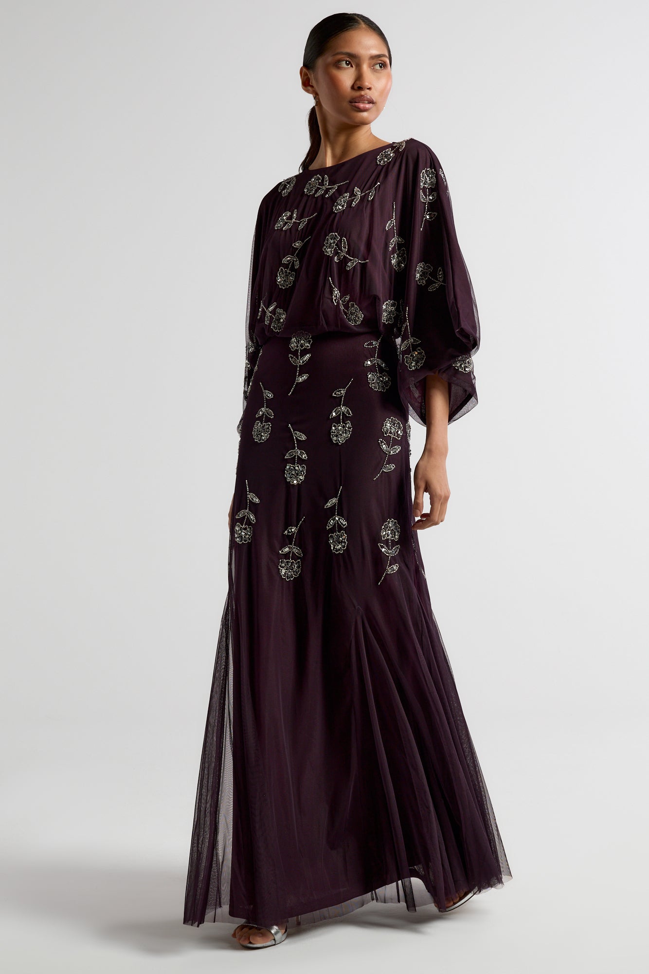 Naida dark purple embellished maxi dress with long sleeves, floral bead details, and floor-length flowing silhouette, suitable for weddings and formal occasions.