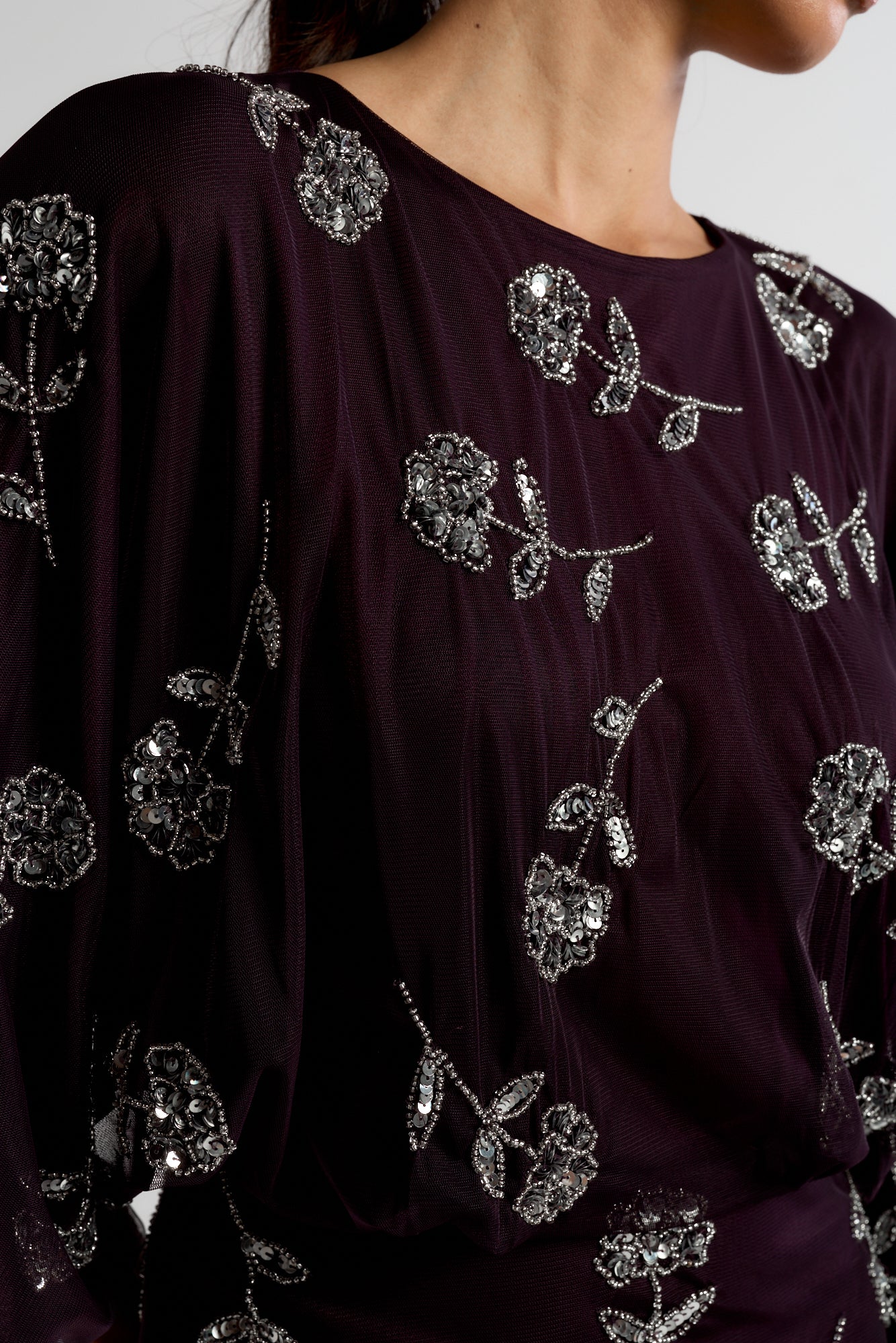 Naida dark purple embellished maxi dress with long sleeves, floral bead details, and floor-length flowing silhouette, suitable for weddings and formal occasions.