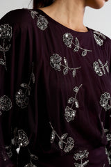 Naida dark purple embellished maxi dress with long sleeves, floral bead details, and floor-length flowing silhouette, suitable for weddings and formal occasions.