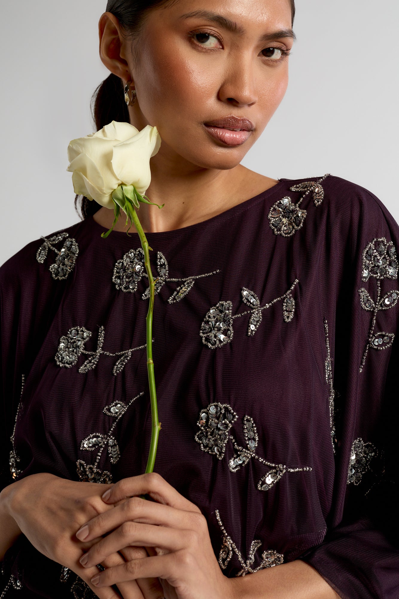 Naida dark purple embellished maxi dress with long sleeves, floral bead details, and floor-length flowing silhouette, suitable for weddings and formal occasions.