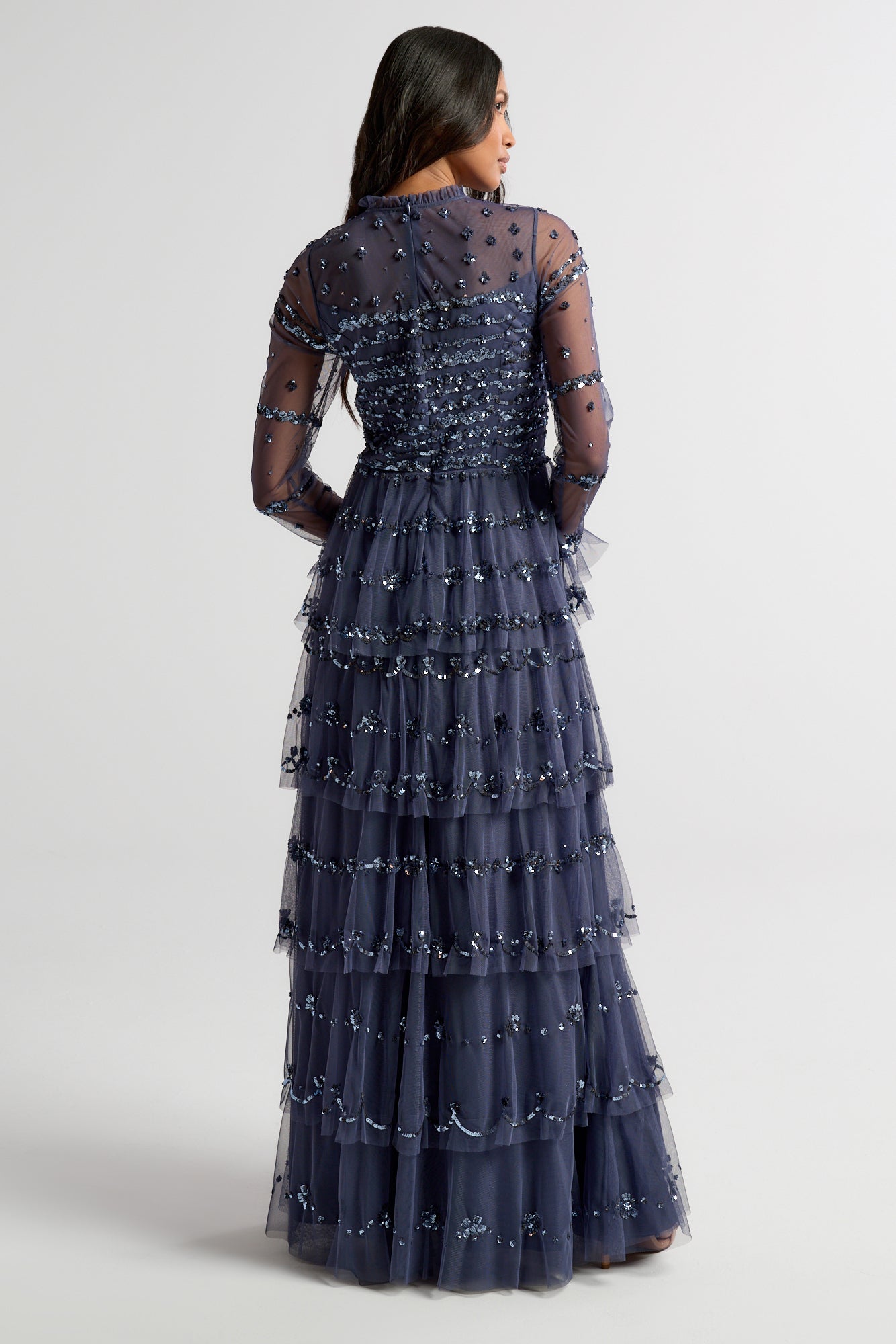 Nerissa dusty navy blue sequin tiered maxi dress with full-length sleeves, perfect for weddings, black tie balls and formal occasions. 