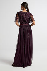 Talia dark purple embellished maxi dress with long sleeves, beaded bodice, and flowing skirt, suitable for bridesmaids or formal occasions.