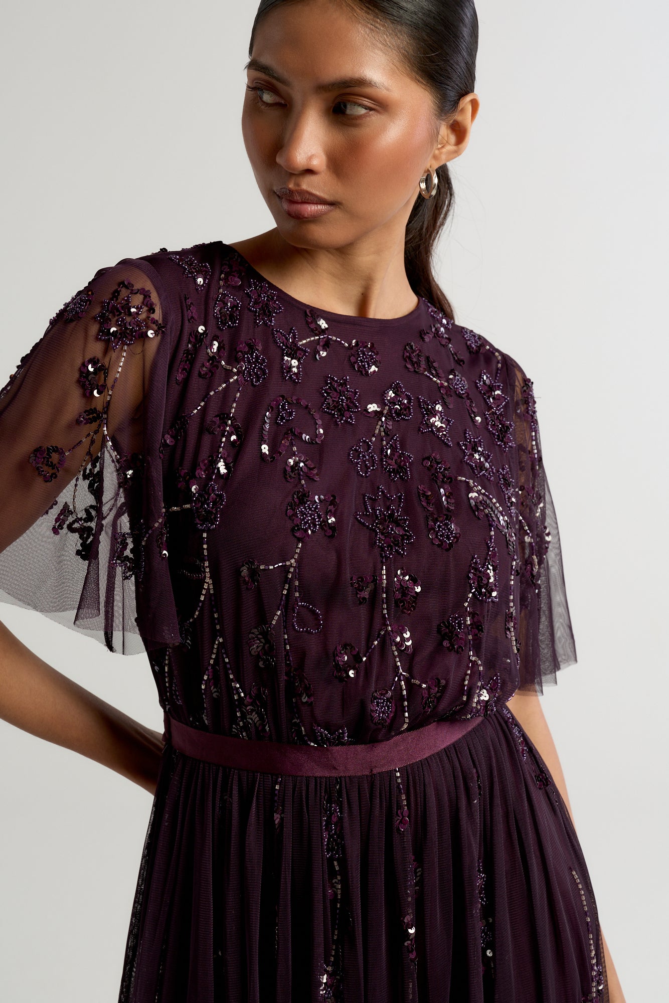Talia dark purple embellished maxi dress with long sleeves, beaded bodice, and flowing skirt, suitable for bridesmaids or formal occasions.