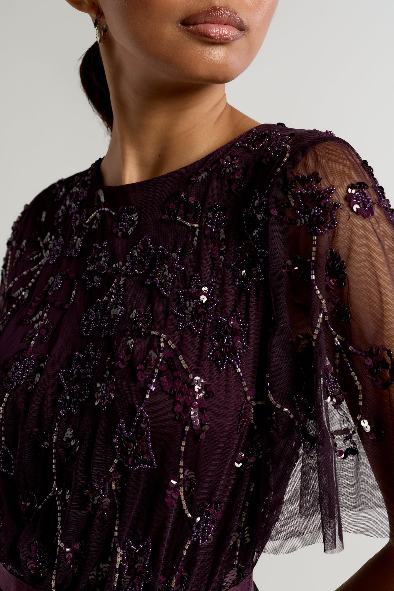 Talia dark purple embellished maxi dress with long sleeves, beaded bodice, and flowing skirt, suitable for bridesmaids or formal occasions.
